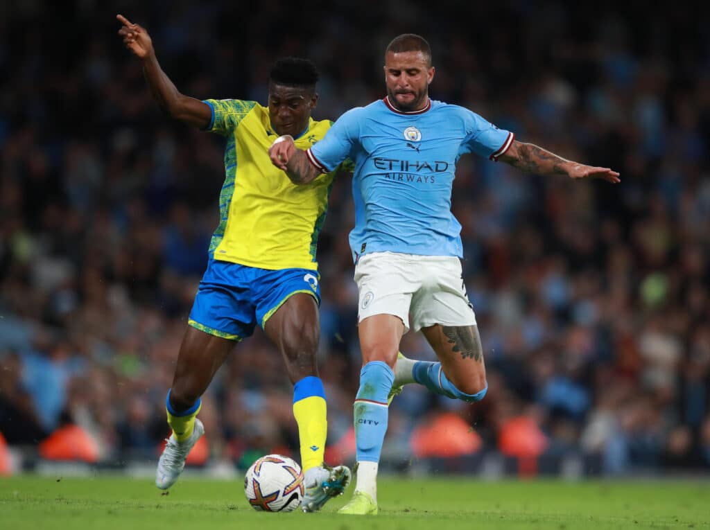 Kyle Walker of Manchester City tackles Taiwo Awoniyi of Nottingham Forest