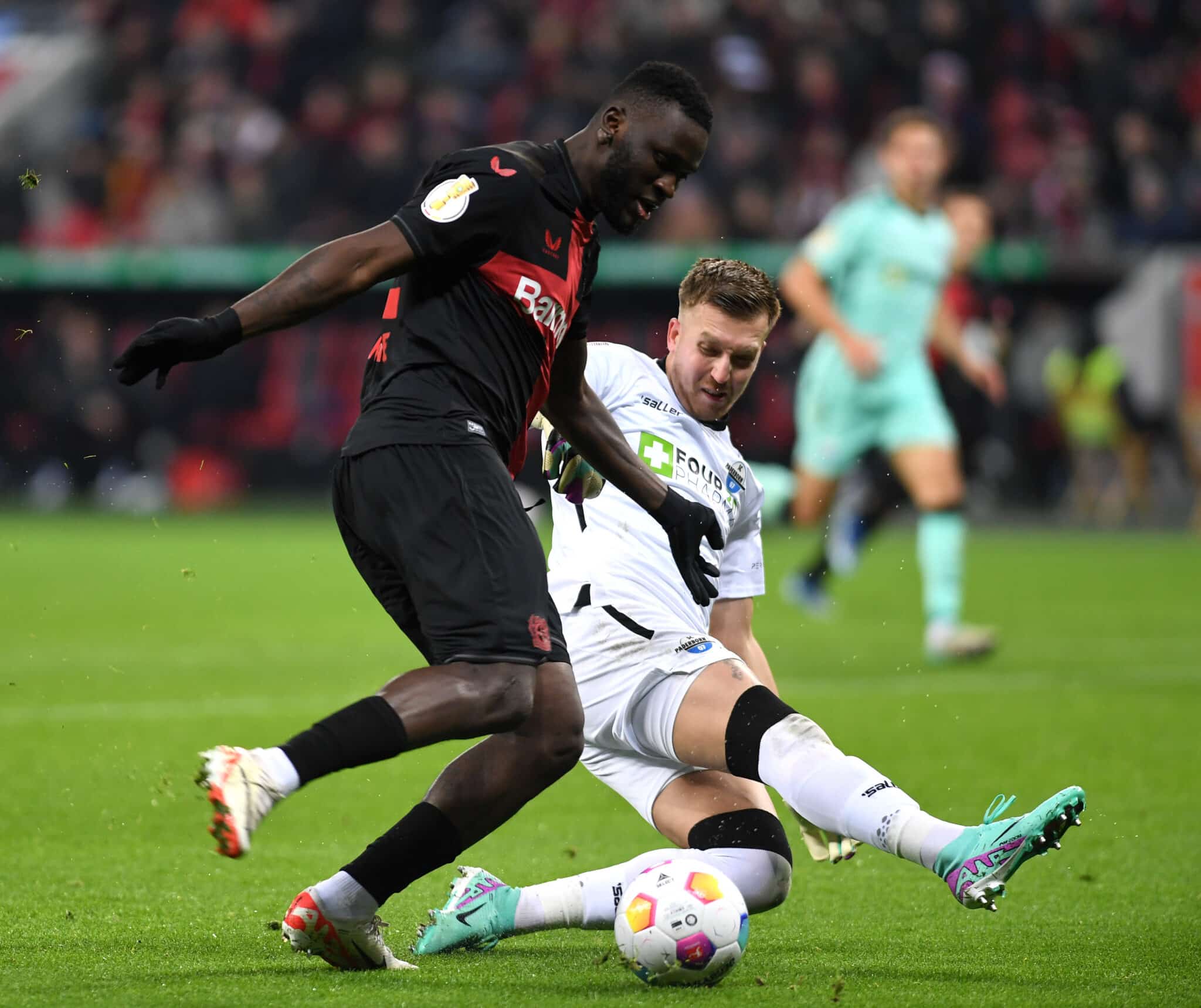 Victor Boniface is challenged by a Paderborn player