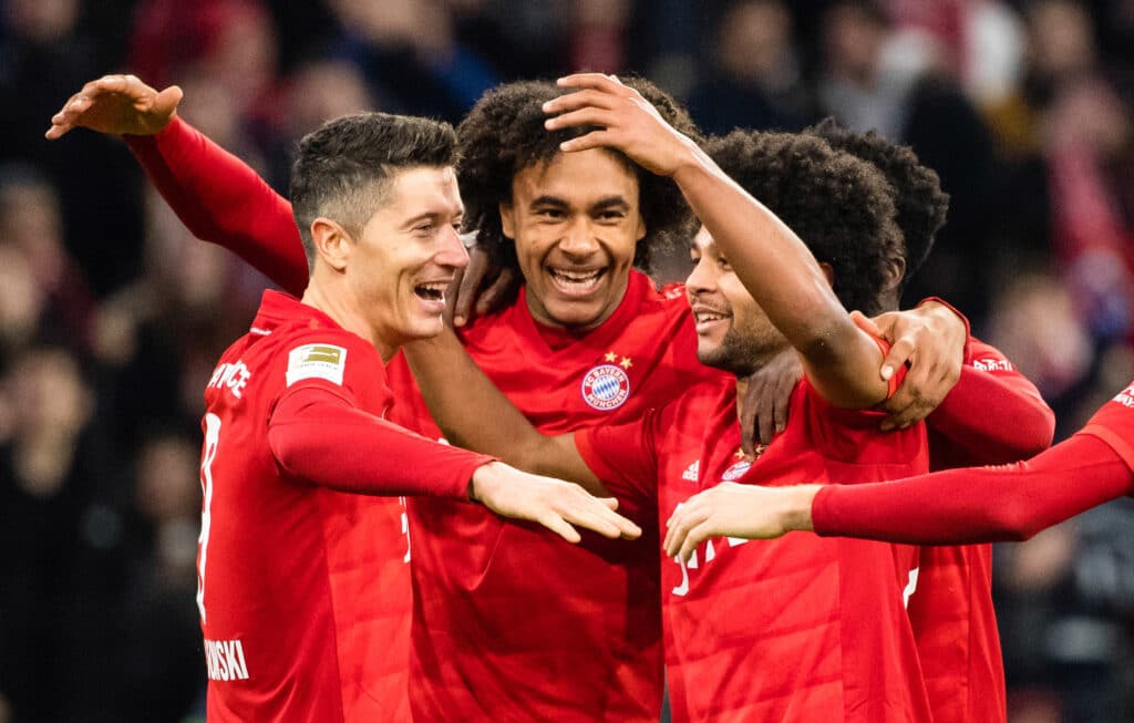 Serge Gnabry (l) cheers with Alphonso Davies (M) and Joshua Zirkzee 